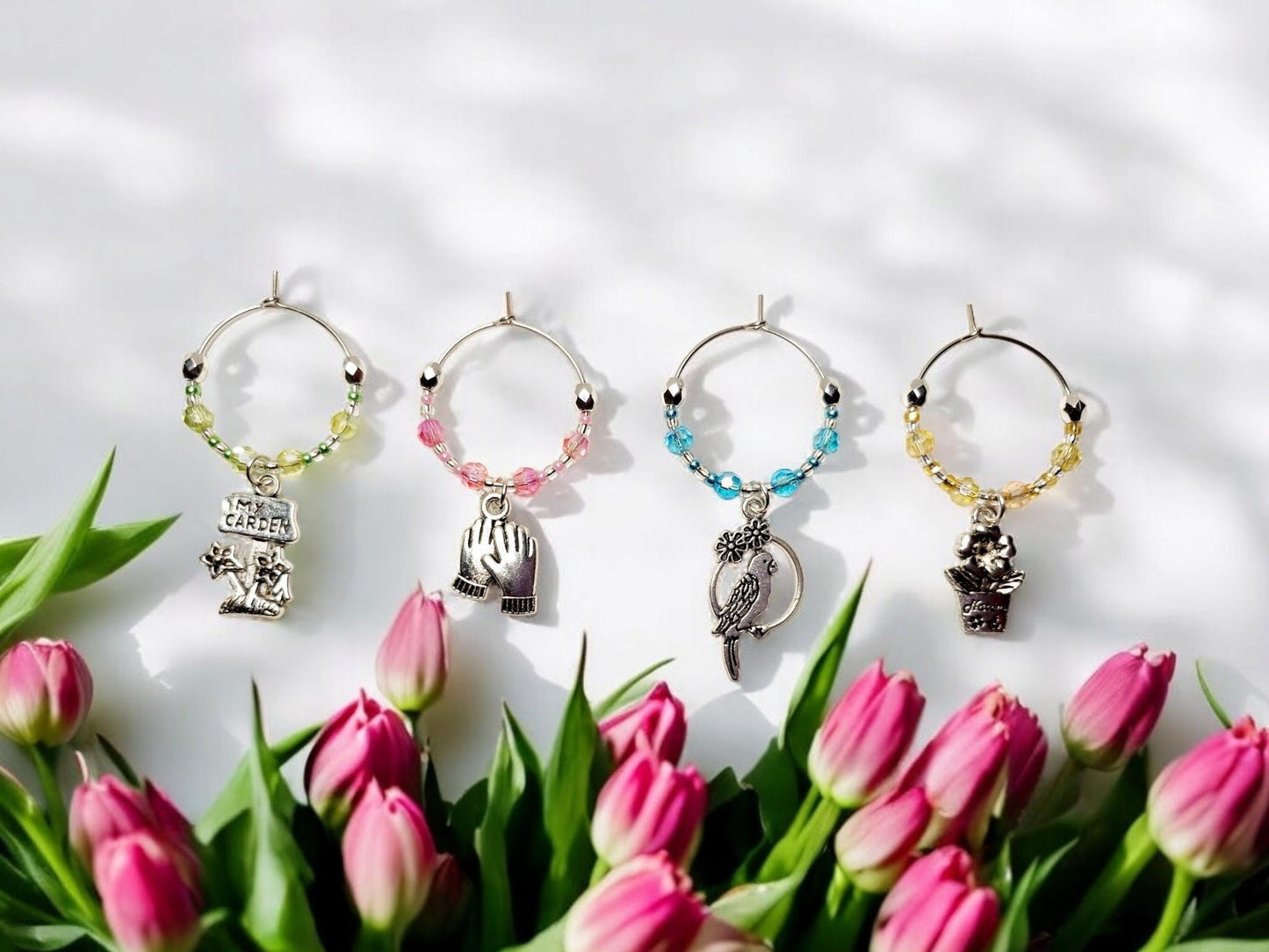 Garden themed wine charms, set of 4 on silver plated holders, in pastel green, yellow, pink and blue.