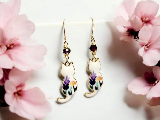 White cat charm dangle earrings with purple and yellow painted flowers and purple glass beading.
