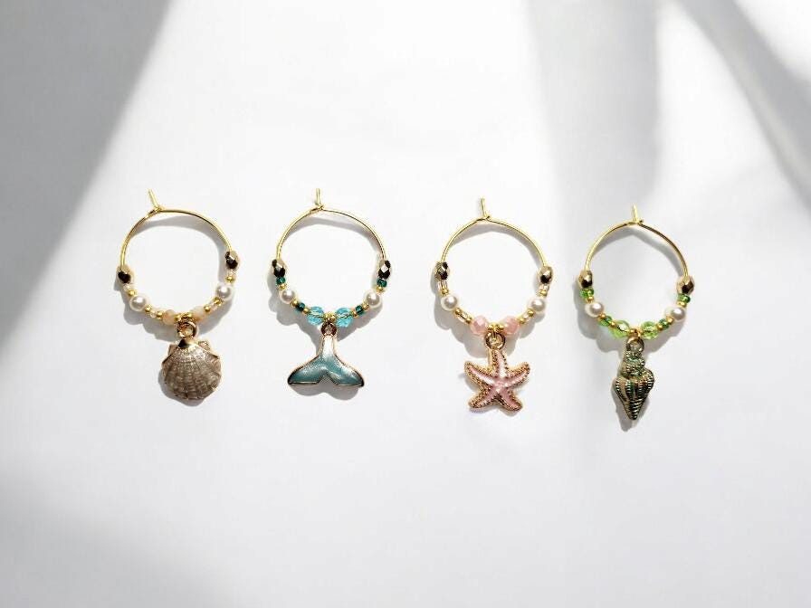 Mermaid Ocean theme enamel Wine charms, set of 4 in pastels white, blue, pink and green on gold plated holders.
