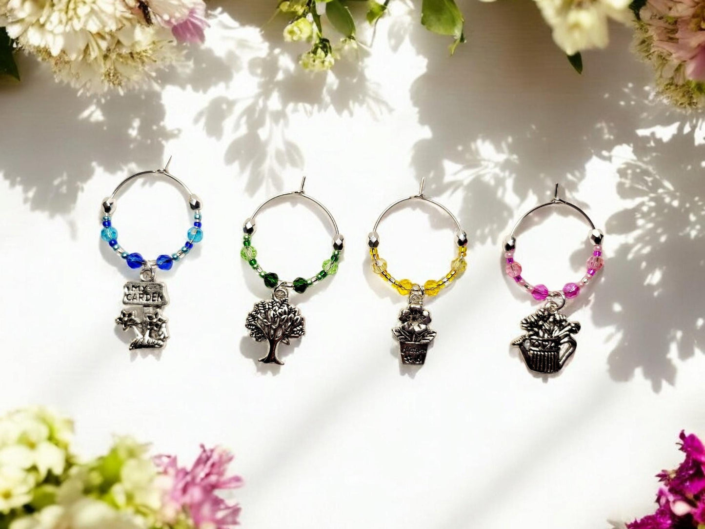 Garden themed wine charms, set of 4 on silver plated holders, with crystal beading in blue, green, yellow and pink.
