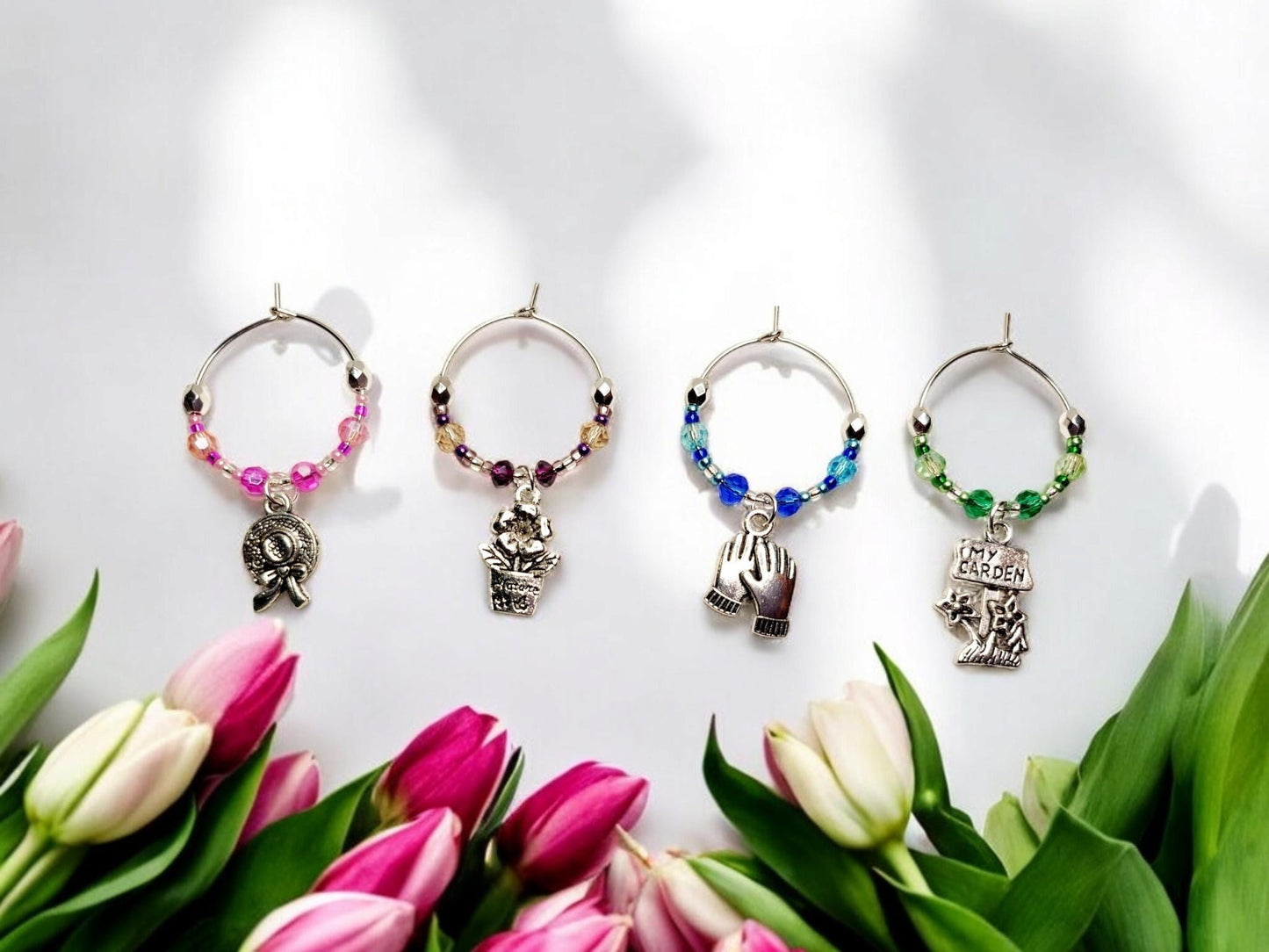 Garden themed wine charms, set of 4 on silver plated holders, with crystal beading in pink, purple, blue and green.