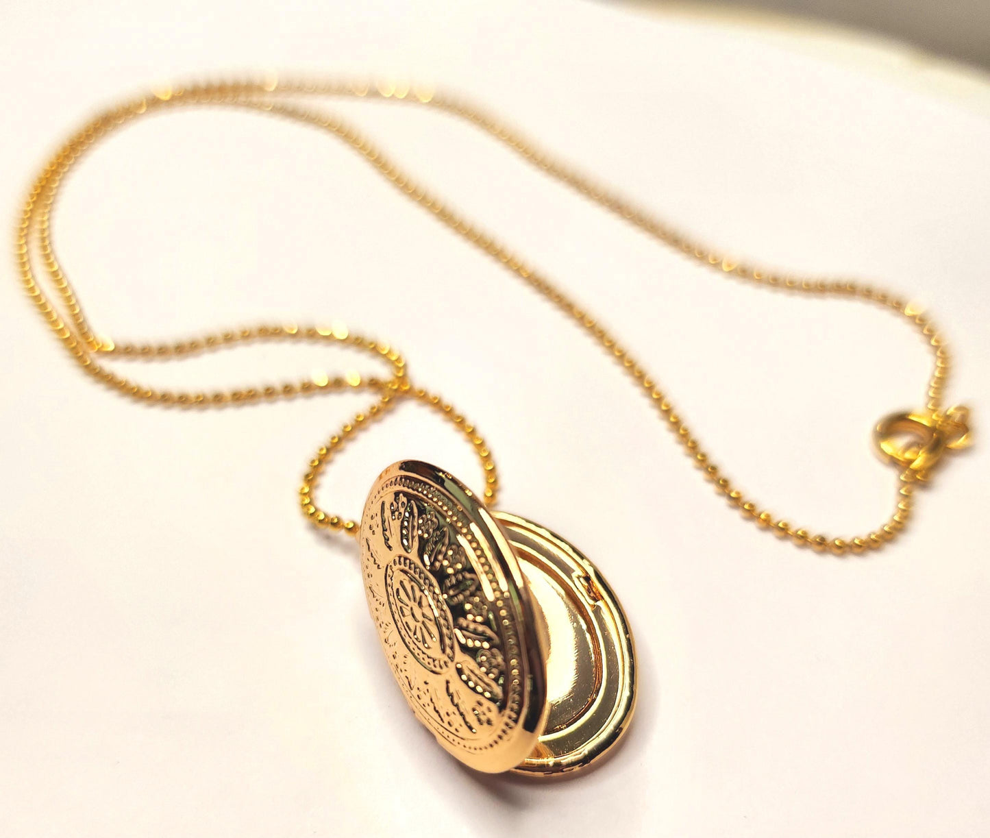 Gold oval locket set on 18inch gold beaded chain