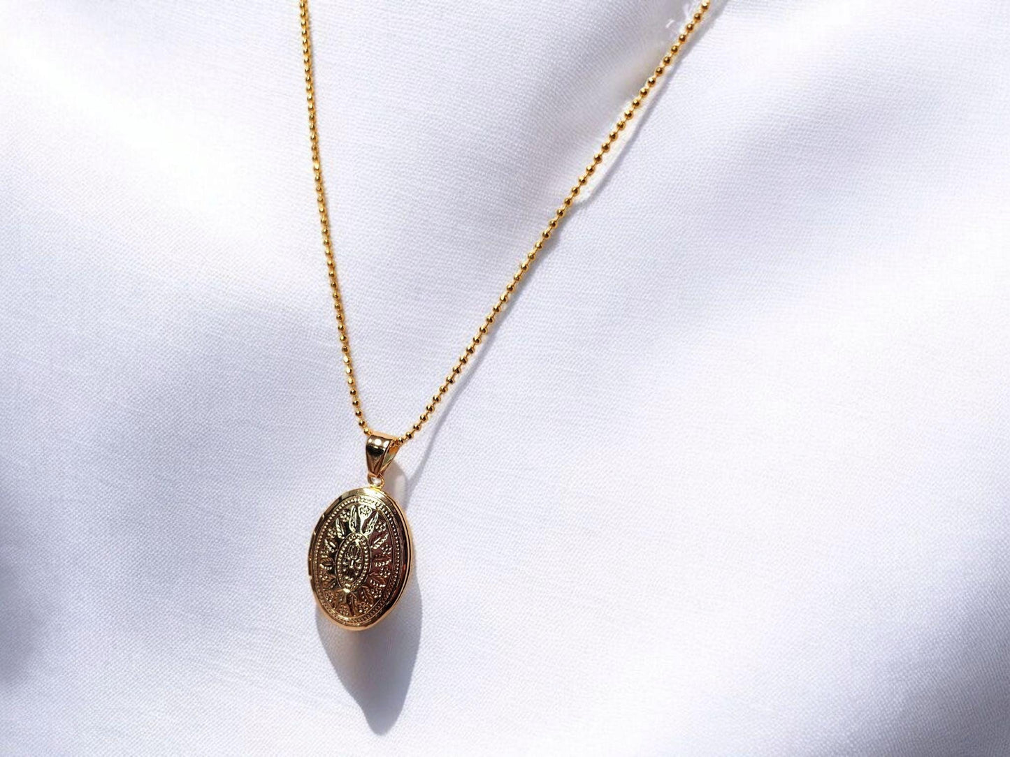 Gold oval locket set on 18inch gold beaded chain